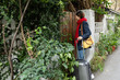 © PR Image Factory - asian Taiwanese lady wearing red scarf going back to her hometown to celebrate chinese new year. she is pushing open main gate of her house with a suitcase