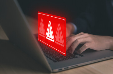 Wall Mural - businessman using laptop showing warning triangle and exclamation sign icon warning of dangerous pro