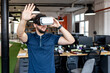 © Westend61 - Young businessman wearing VR glasses gesturing at office