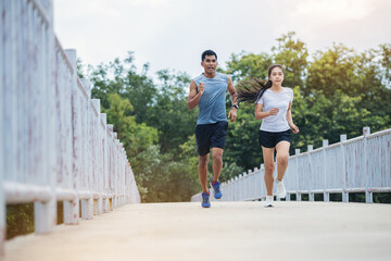 Poster - Young couple running together on road across the bridge. Couple, fit runners fitness runners during outdoor workout.