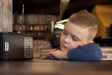 Cute Boy At Cafe Table With Old Vintage Radio
