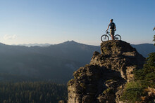 A Mountain Biker On A Spire At Sunset On Barker Pass Above Lake Tahoe In California.