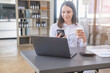 © PHAISITSAWAN - marketing, finance, accounting, planning, White biracial businesswoman using mobile phone to contact clients informing them of company business partnerships on office table with laptop and documents.