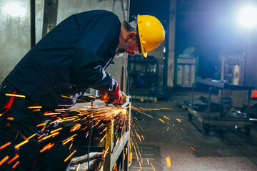 Industrial worker cutting metal.