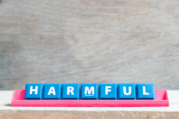 Canvas Print - Tile alphabet letter with word harmful in red color rack on wood background