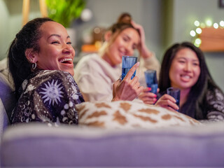 Poster - Friends watching television in pajamas in living room