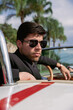 © VictorHugo - young man in a convertible car looking out to sea, man in car