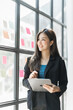 © M+Isolation+Photo - Pretty asia business woman bookkeeper brainstorming and working in modern office workplace with sticky notes or post it at windows.
