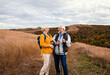 © Zoran Zeremski - Active senior couple with backpacks hiking together in nature on autumn day.