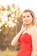 © Bjorn B - A fragile, tender girl in a red vintage dress standing near a forest during the golden hour. Background of a mystical green forest. Artistic Photography. High quality photo