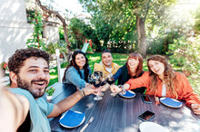 Friends Group Having Fun Together In Backyard Garden Party - Young People Enjoying Time Drinking Red Wine At Farm House Vineyard - Friendship And Reunion Lifestyle Concept