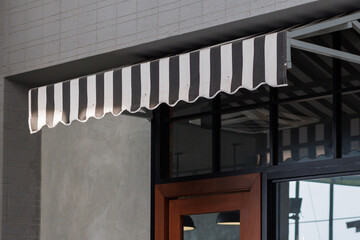 Wall Mural - the black and white striped awning over the shop door. exterior canvas roof. blind sun