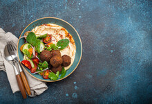 Middle Eastern Arab Meal With Fried Falafel, Hummus, Vegetables Salad With Fresh Green Cilantro And Mint Leaves In Ceramic Bowl On Stone Rustic Background Top View. Arabic Cuisine, Space For Text