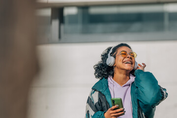 Canvas Print - fashionable urban girl listening to music with headphones on the street