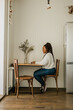 © satura_ - Cheerful african american woman using laptop while sitting on chair in living room, vertical copy space and place for text - student, video call and working at home concept
