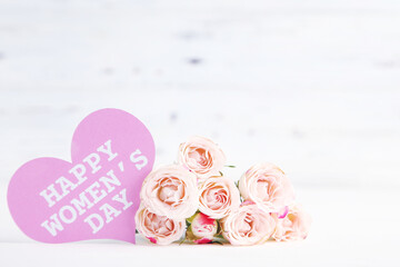 Canvas Print - Bouquet of roses and card in shape of heart with text Happy Women's Day on white wooden background