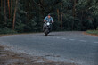 © perfectlab - Blurred Motion A young man biker in a helmet quickly rides at high speed on a forest road, in motion