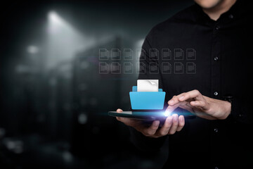 A man works on a tablet with a file and documents .