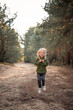 © mariyakuprevich - Little blonde girl dancing jumping on the sand in a pine forest
