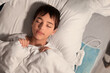 © Pixel-Shot - Little boy sleeping on electric heating pad in bedroom at night, top view