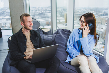 Two business people working remotely online using a laptop. Colleagues work remotely in the workspace.