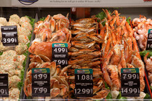 Fresh Seafood At A Grocery Store Including Whole Crab, Crab Legs, And Shrimp.