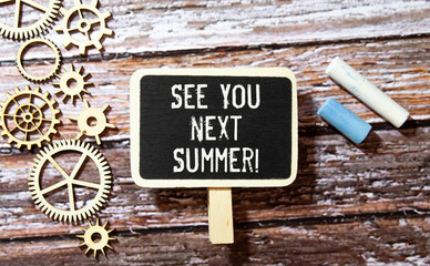 See you next Summer written on a note at the office table with empty space for text.