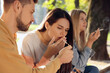 © New Africa - People smoking cigarettes outdoors on sunny day