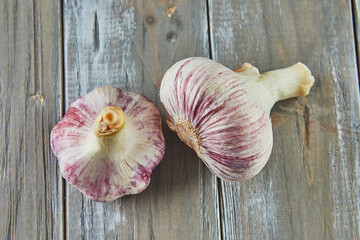 Poster - Fresh bulbs of garlic stacked on wooden gray background