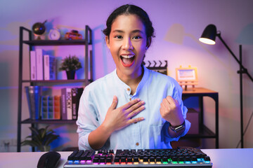 Young Asian woman gamer open mouth with emotional excited and shocked with wearing headset winning the game, celebrating victory expressing success.