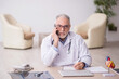 © Elnur - Old male doctor in telemedicine concept