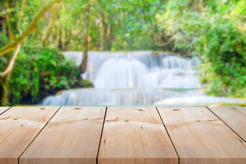 Wall Mural - Close-up empty wooden plank long table top on vintage style for put product and anything display with outdoor theme on blurred waterfall summer background