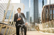 © oneinchpunch - Young handsome man with business suit driving bicicyle to go to office - Corporate businessman portrait biking in the city, concepts about business, green mobility and lifestyle