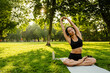 © Drobot Dean - Young brunette asian woman practicing yoga during workout in park