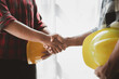 © kamiphotos - Team engineers and architects shake hands with the condo project owners after the meeting to present room plans and details of the condo building structure. Concept of building design and construction