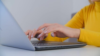 Female programmer typing code on a laptop. Freelance writer person typing text on modern notebook computer at home