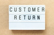 Lightbox with word customer return on wood background