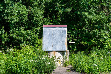 Wall Mural - Old well with iron bucket on long forged chain for clean drinking water