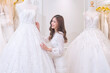 © Tongpool - Women happy see many wedding dresses on shelf and in hands choose dresses for the wedding day