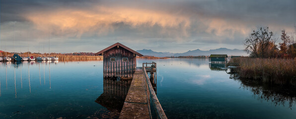 Aufkleber - Scenic nature landscape. Sunrise on Chiemsee lake with vivid sky. Beautiful alpine sunset view on mountain lake and fishing hut near Rimsting at famous Chiemsee, Bavaria, Germany. nature background