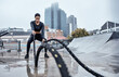© D Lahoud/peopleimages.com - Fitness, workout and black woman with rope in city for cardio exercise, bodybuilder training and sports. Wellness, motivation and female athlete focus with gear for strong muscles, power and energy