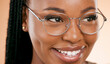 © J Maas/peopleimages.com - Black woman, face zoom and smile with glasses, vision and prescription lens isolated on studio background. Eyewear, eye care and healthcare for eyes, happy girl with fashion frame and optometry
