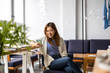 © pikselstock - Young woman using smartphone in loft office