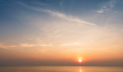 Sunset sky clouds over horizon sea in the morning with orange, red, yellow sunrise golden hour and blue background 