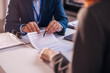 © kerkezz - The real estate agent closes the deal with the client and they sign the contract.