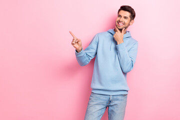 Canvas Print - Photo of thoughtful charming man wear blue hoodie smiling arm chin looking pointing empty space isolated pink color background