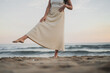 © ADDICTIVE STOCK - Anonymous carefree young Hispanic lady kicking sand on seashore