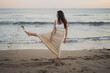 © ADDICTIVE STOCK - Carefree young Hispanic lady kicking sand on seashore