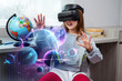 © Oksana Klymenko - Child girl wearing virtual reality headset and looking at digital space system with planets or Universes. Future learning and education