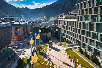 Cityscape of Andorra la Vella capita city of Andorra wit men sitting on poles, at the foothill of Pyrenees Mountain range.